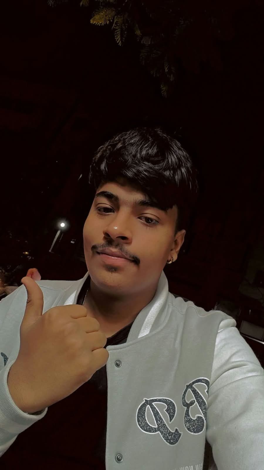Shubh at night, giving a thumbs up